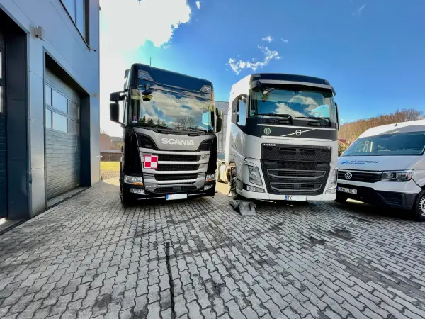 Ciągnik siodłowy Scania, Volvo FH i bus zaparkowane przed halą serwisową Klinika-DPF w Tymbarku