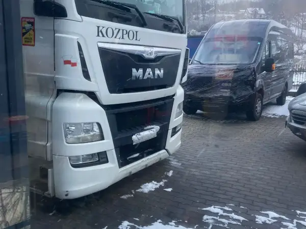 Ciągnik siodłowy MAN TGX i bus dostawczy na zaśnieżonym placu przed warsztatem