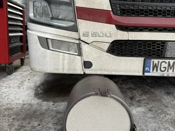 Wymontowany filtr cząstek stałych leżący przed ciągnikiem siodłowym Scania S500 w serwisie w Tymbarku