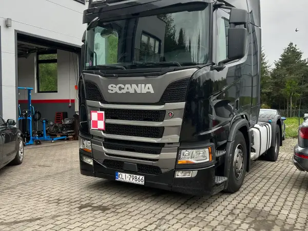 Czarny ciągnik siodłowy Scania S450 przed bramą warsztatu Klinika-DPF