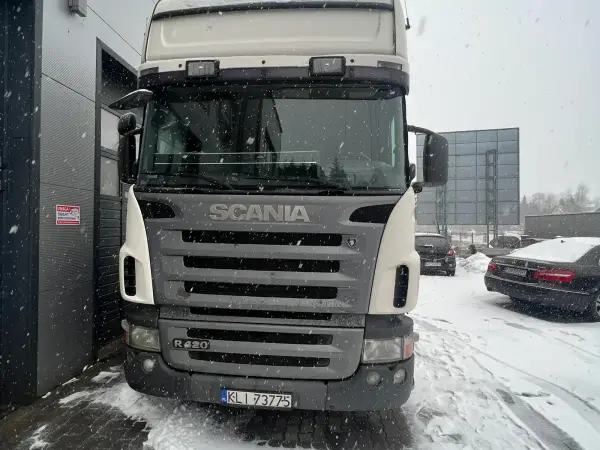 Kremowa Scania R420 na zaśnieżonym placu przed warsztatem zimą