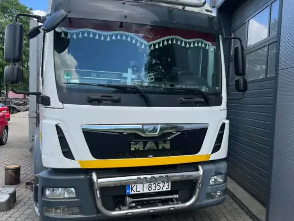 Pomarańczowy DAF XF i dwa autobusy miejskie ustawione w rzędzie przed serwisem w Tymbarku
