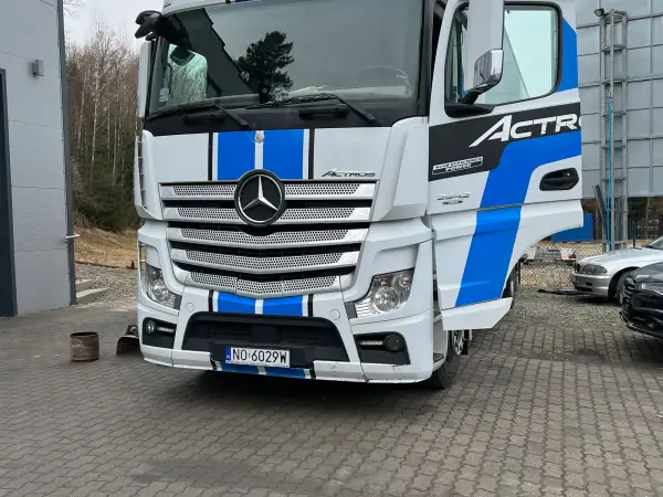 Mercedes-Benz Actros 2542 w biało-niebieskim malowaniu przed halą serwisową